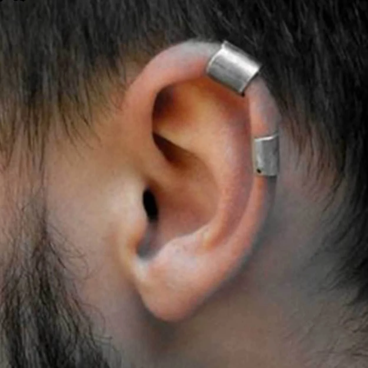 Man med flera ear cuff örhängen